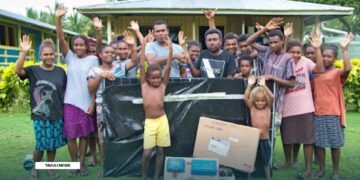Marunga Community High School Principal Markwest Paraihaga (L) received the Starlink set from EMC Project Officer Jonas Kurio in a brief handover at the school flanked by some of their students.