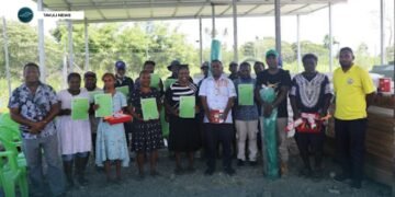 Member of Parliament for NGC, Dr. Paul Bosawai, with school recipient representatives flanked by constituency officers, showing off their handover certificates and some of the handover material supplies.